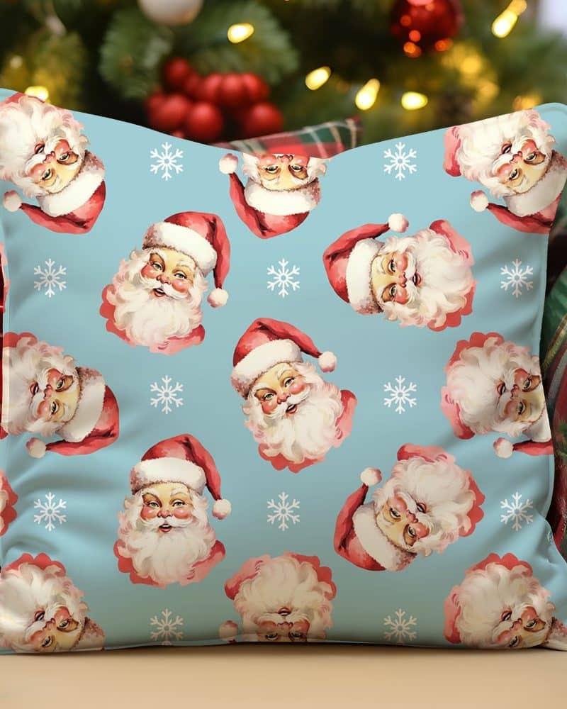 Light blue throw pillow with a repeating pattern of vintage Santa Claus illustrations and snowflakes.