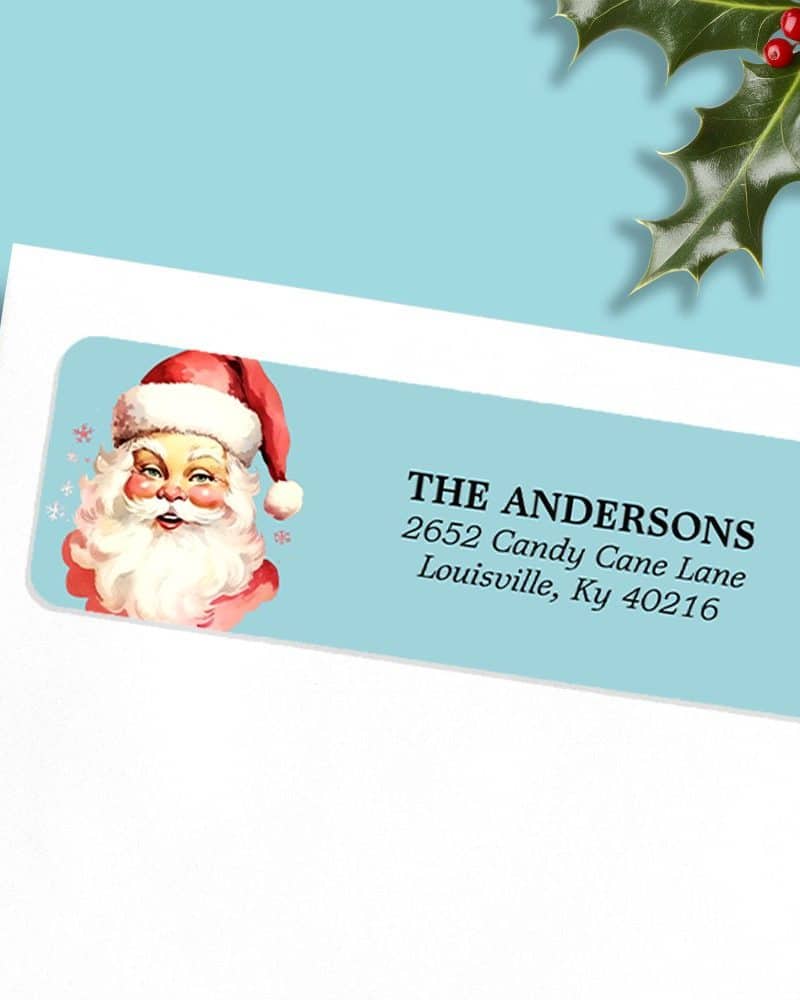 Light blue rectangular return address label with a vintage illustration of Santa Claus and the address The Andersons, 2652 Candy Cane Lane, Louisville, Ky 40216.