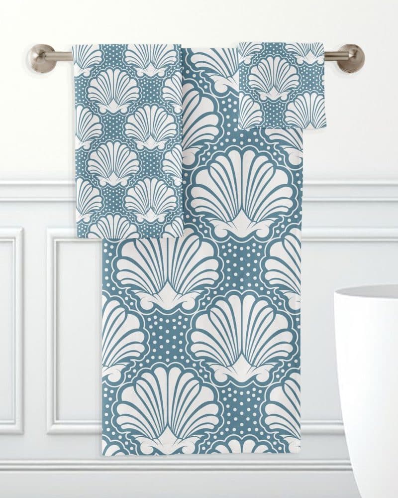Teal bath towels with a white seashell pattern.