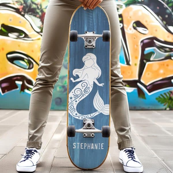 Person Holding A Blue Skateboard With A White Mermaid Design And The Name Stephanie.