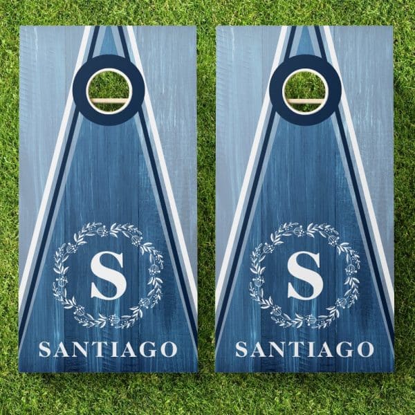 Pair Of Blue Cornhole Boards With White Lettering. Each Board Displays A Monogram In A Wreath And The Name Santiago.