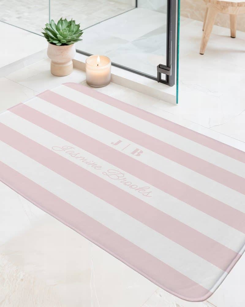 Pink and white striped bath mat with the name Jasmine Brooks and initials J|B.