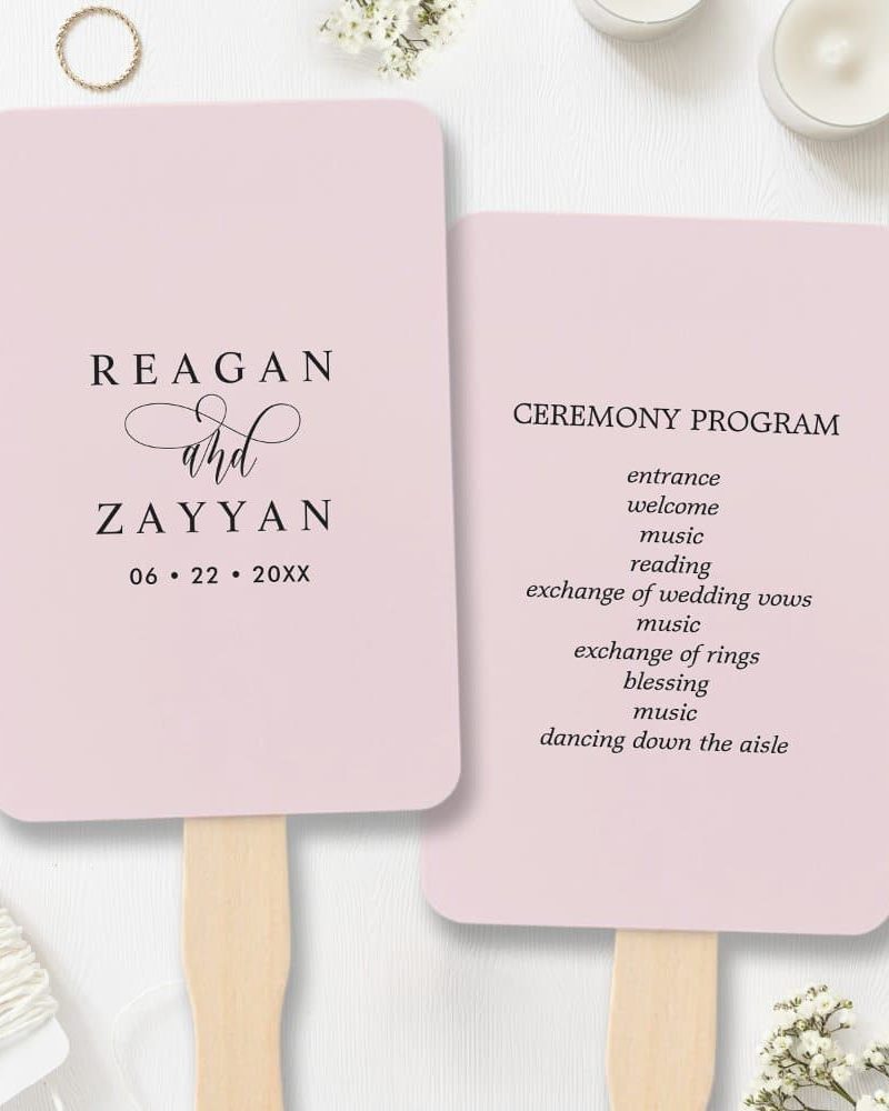 Pale pink wedding ceremony program fans; one features the couple's names and wedding date, the other lists the ceremony events.