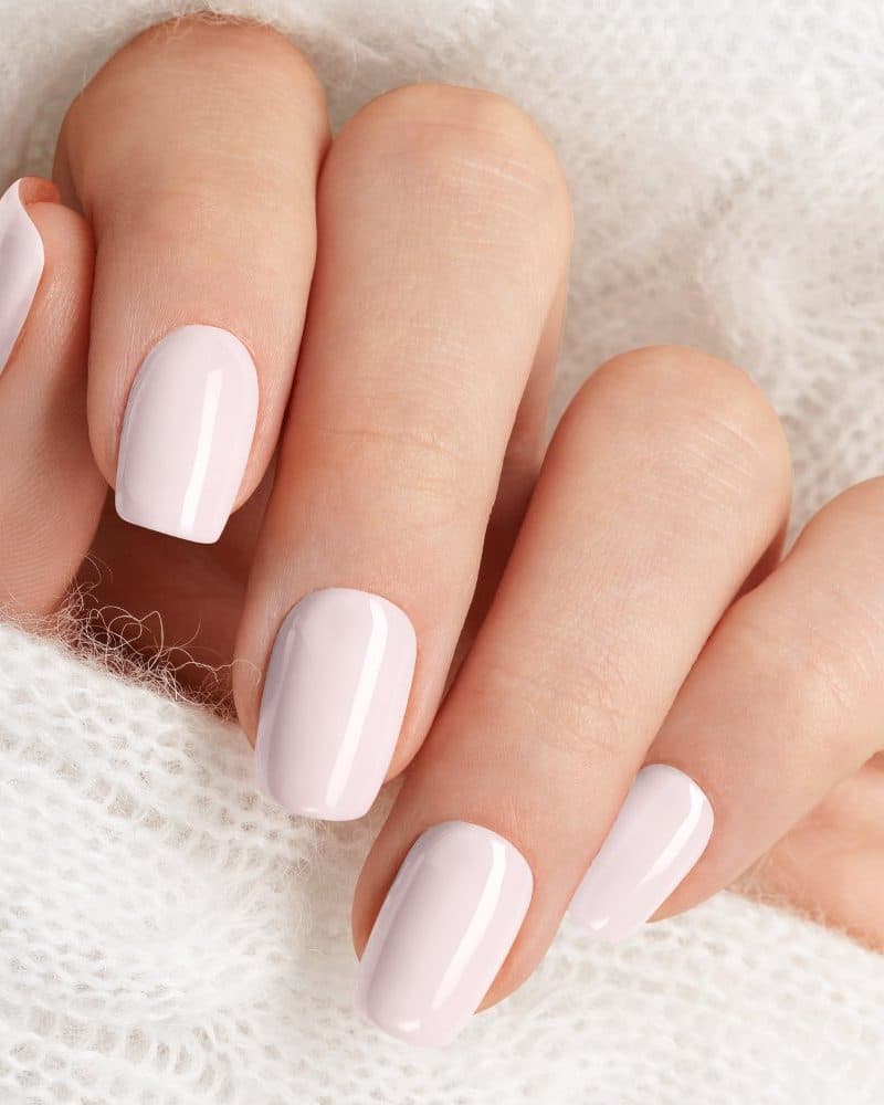 Hand with light pink nail polish.