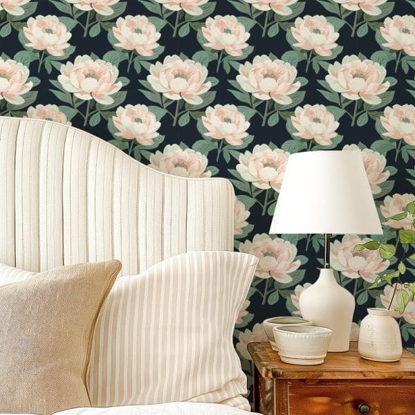 A Bedroom Headboard And Pillows Against A Wall Covered In A Dark Floral Wallpaper Featuring Light Pink Peonies.