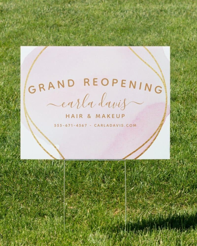 Grand reopening sign for Carla Davis Hair & Makeup, with contact information.