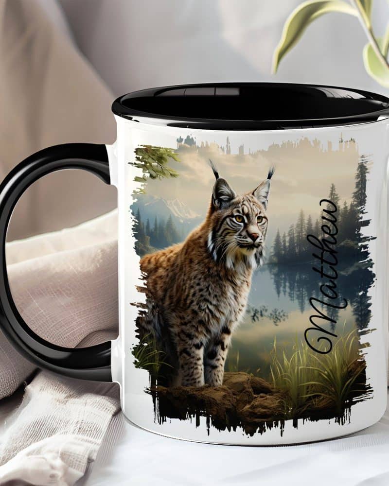 A black and white coffee mug featuring a lynx in a forest landscape. The name Matthew is printed on the mug.