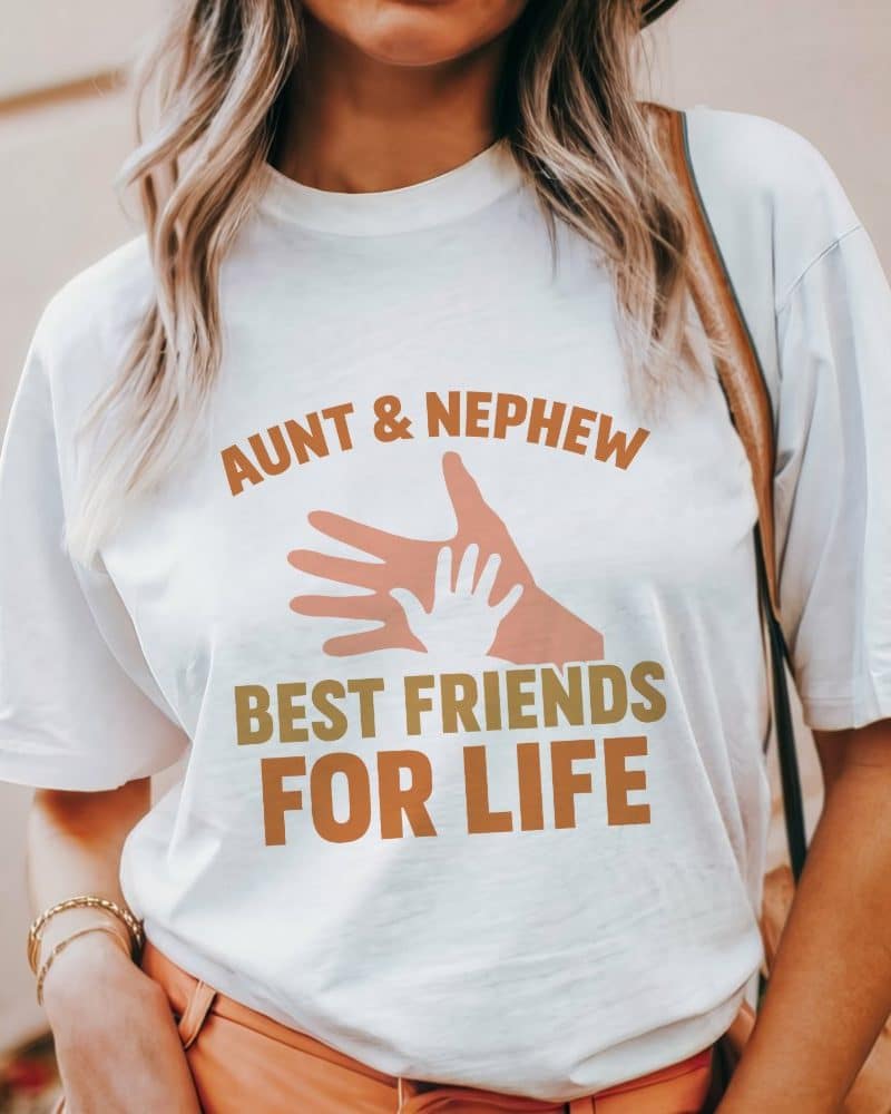 Woman wearing a white t-shirt that says Aunt & Nephew Best Friends For Life, with an image of two hands.