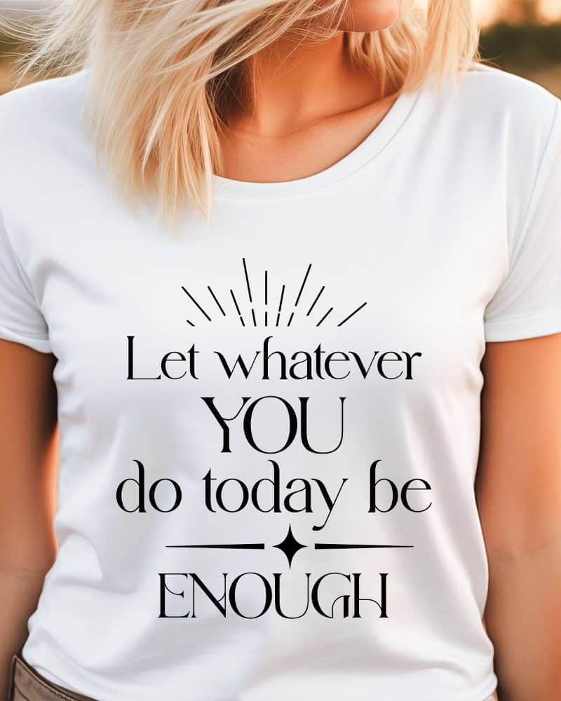 Woman wearing a white t-shirt with the text Let whatever YOU do today be ENOUGH.
