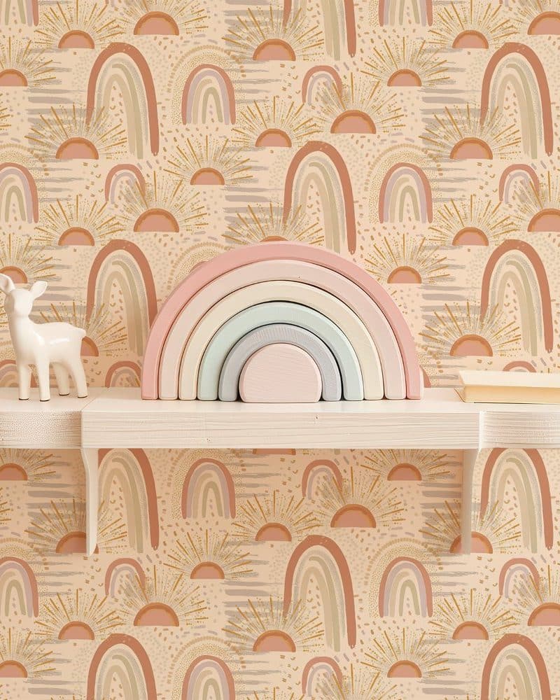 Pastel rainbow stacking toy on shelf against a wall with a repeating pattern of rainbows and sunbursts.
