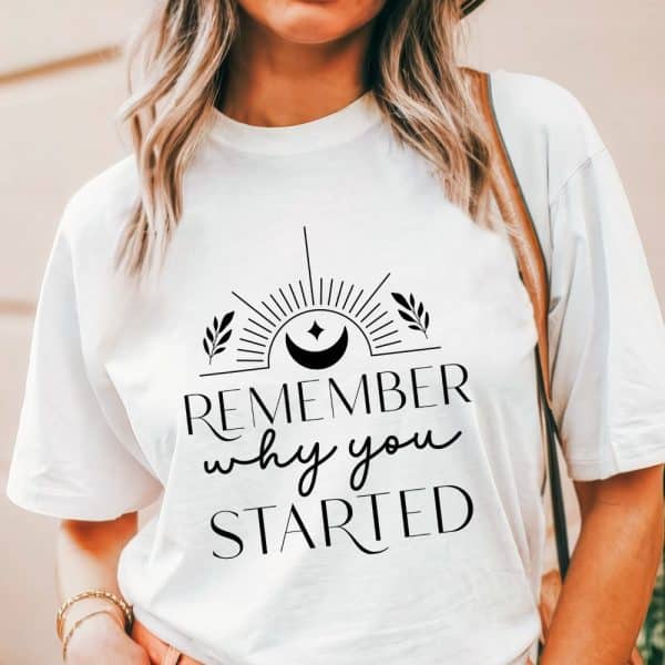 White T-Shirt With The Text Remember Why You Started, Centered, In A Stylized Font With A Sun And Moon Graphic Above.
