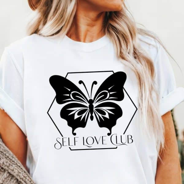 White T-Shirt With A Black Butterfly Graphic And The Words Self Love Club.