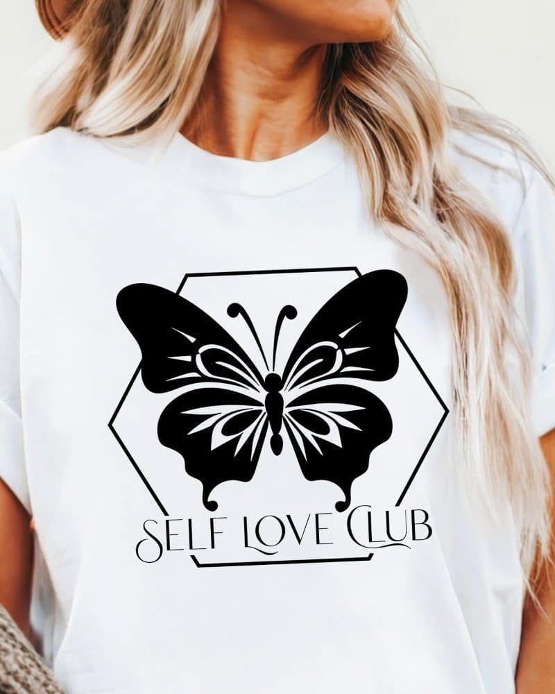 White t-shirt with a black butterfly graphic and the words Self Love Club.