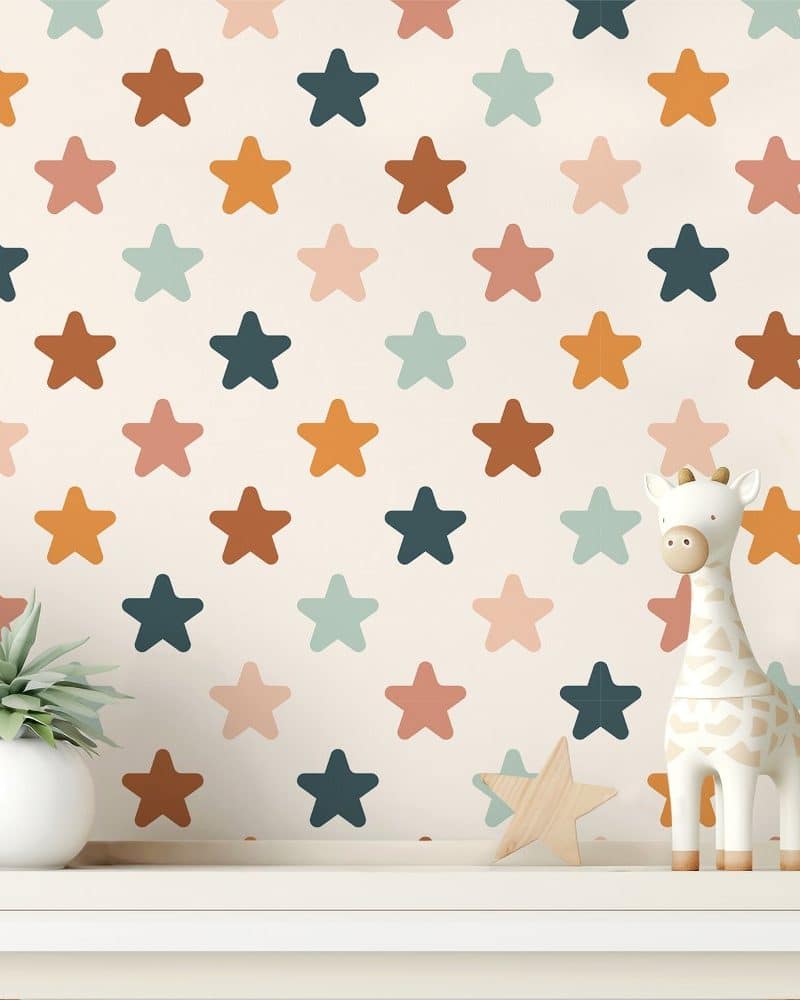 A white shelf holds a small potted plant and a giraffe toy in front of a wall covered in a multicolored star pattern.