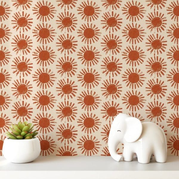 A White Shelf Displays A Small Potted Succulent And A White Elephant Figurine Against A Background Of Wallpaper Featuring A Repeating Pattern Of Burnt Orange Suns.