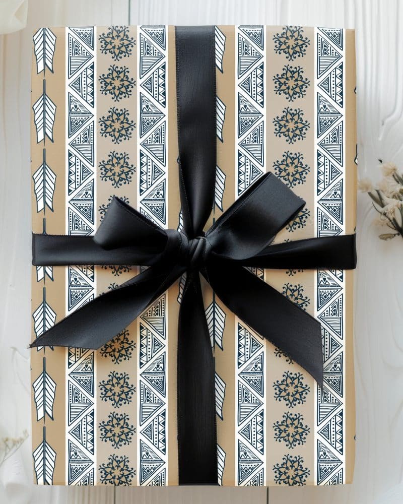 Tan gift box with a navy and white geometric pattern, tied with a black ribbon.