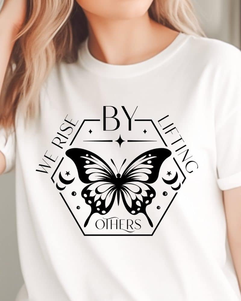 White t-shirt with a black butterfly design centered on the chest. The butterfly is inside a hexagon with the words We Rise By Lifting Others.