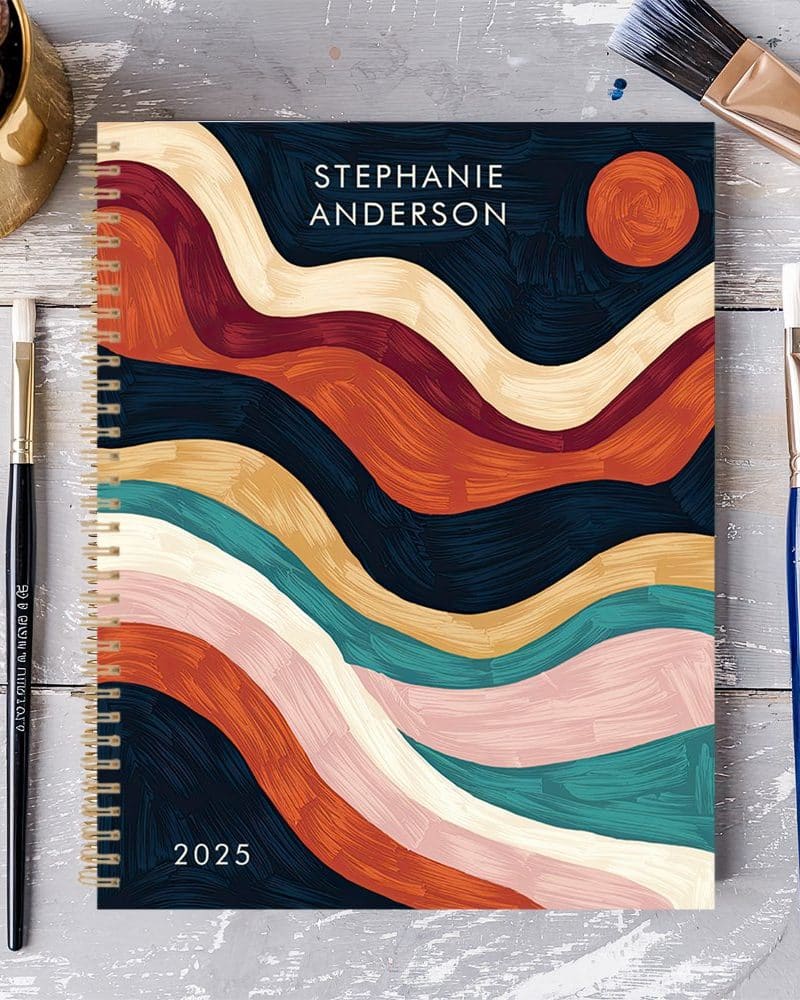 2025 spiral bound planner with abstract paint stroke design in autumnal colors, personalized with the name Stephanie Anderson.
