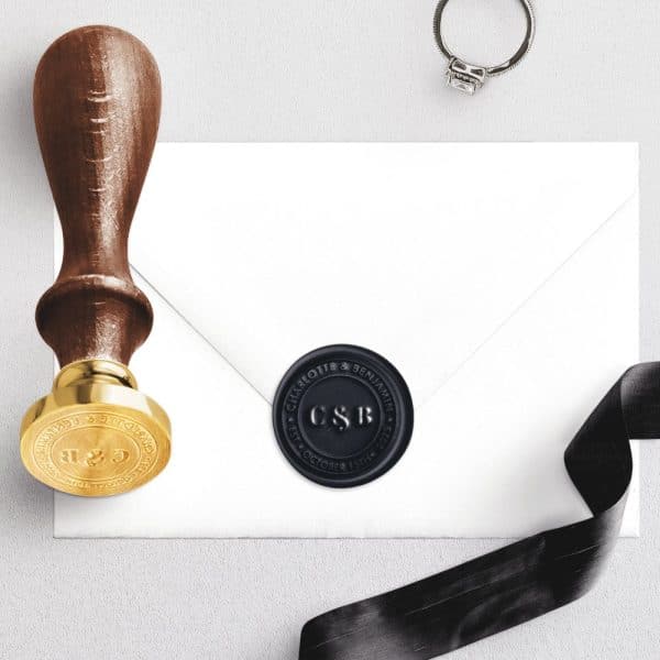 A Black Wax Seal With Initials Cs&Amp;B On A White Envelope.