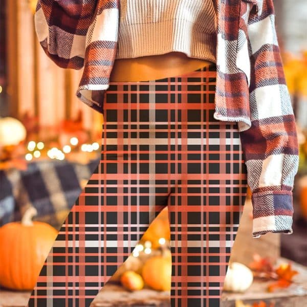 Close-Up Of A Person Wearing Black And Coral Plaid Leggings.