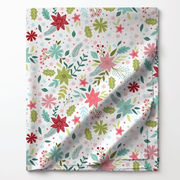 Folded Fabric With A Repeating Pattern Of Red, Pink, Green, And Blue Flowers And Leaves On A White Background.