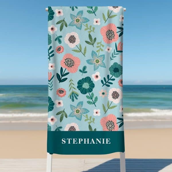 A Teal Beach Towel With A Floral Pattern And The Name Stephanie At The Bottom.