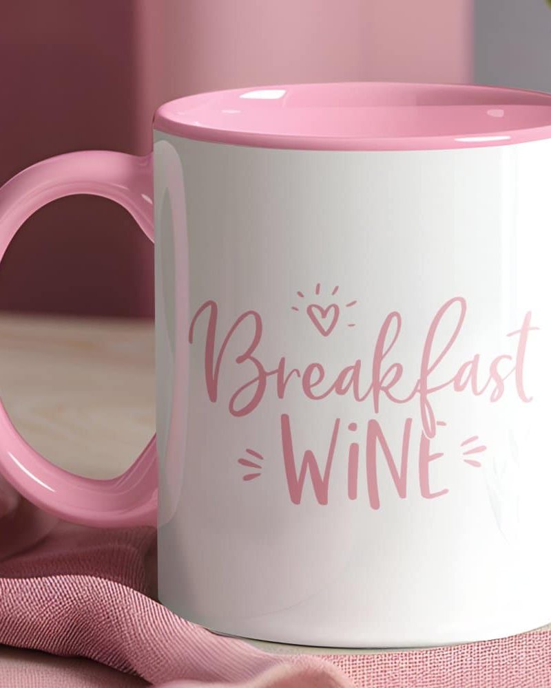 Pink mug with the phrase Breakfast Wine in pink lettering.