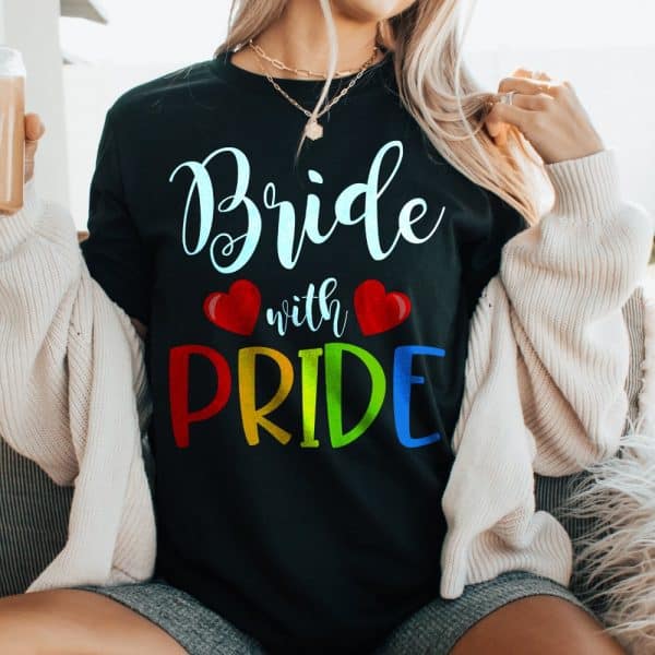 Woman Wearing A Black T-Shirt That Says Bride With Pride In Rainbow Letters.
