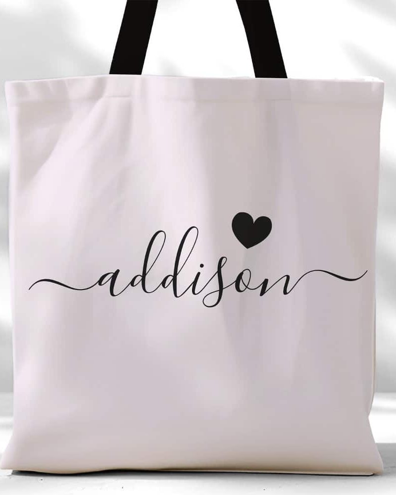 White tote bag with black handles and the name Addison in elegant script with a small heart.