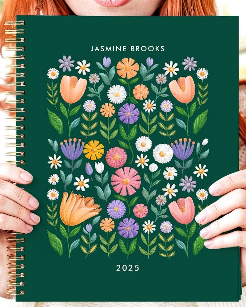 Person holding a 2025 planner with a floral design.