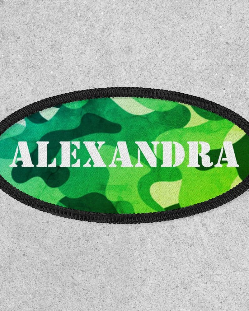 Oval green camouflage patch with the name Alexandra in white.