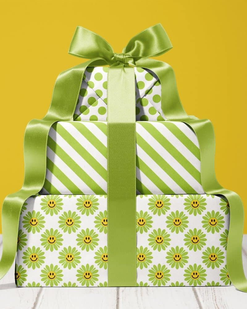 Stack of three presents wrapped in green and white paper with a large green bow.