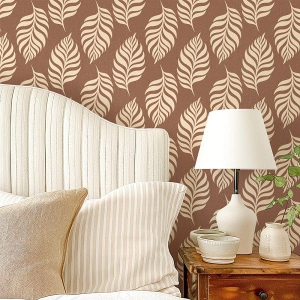 A Bedroom Headboard And Pillows Against A Wall With A Repeating Leaf Pattern Wallpaper.