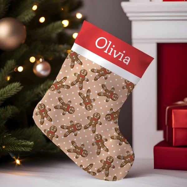 Personalized Christmas Stocking With A Beige Background, Featuring A Repeating Pattern Of Gingerbread Men And White Polka Dots. The Stocking'S Cuff Is Red And White, With The Name Olivia Printed On It.