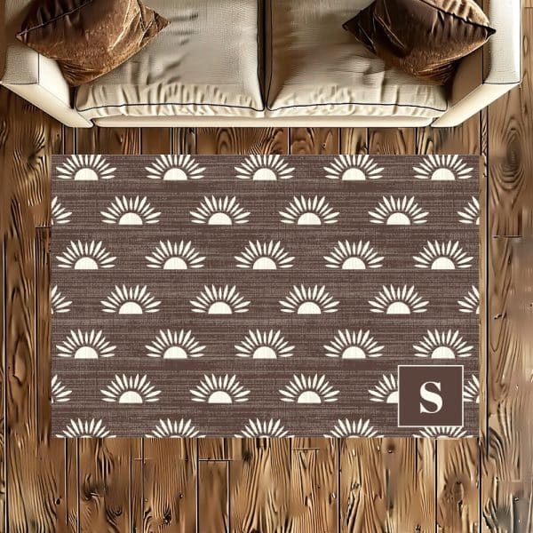 Brown Area Rug With A Repeating Pattern Of Off-White Stylized Suns And A Monogrammed S In The Corner.