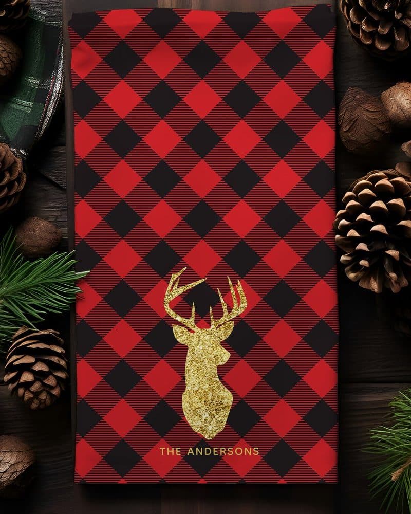 Red and black buffalo plaid tea towel with a gold glitter deer head and The Andersons text.