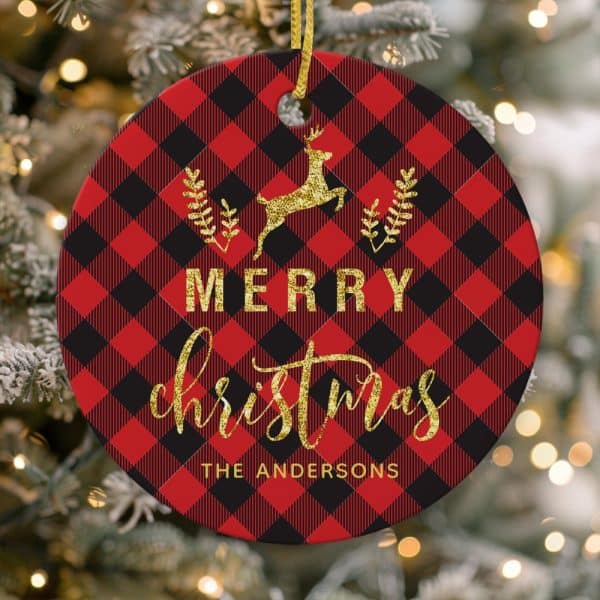 Round Christmas Ornament With Red And Black Buffalo Plaid Pattern, Gold Glitter Reindeer, Merry Christmas Text, And The Andersons Family Name.