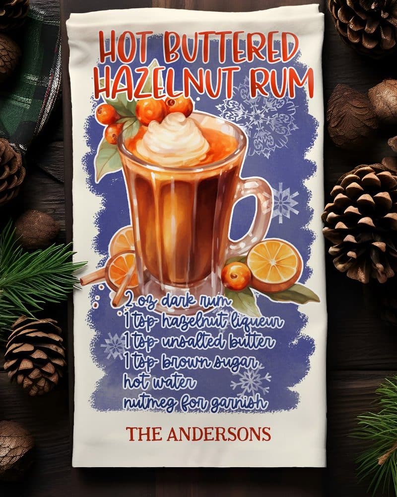 Tea towel with illustration of a mug of hot buttered hazelnut rum and recipe.