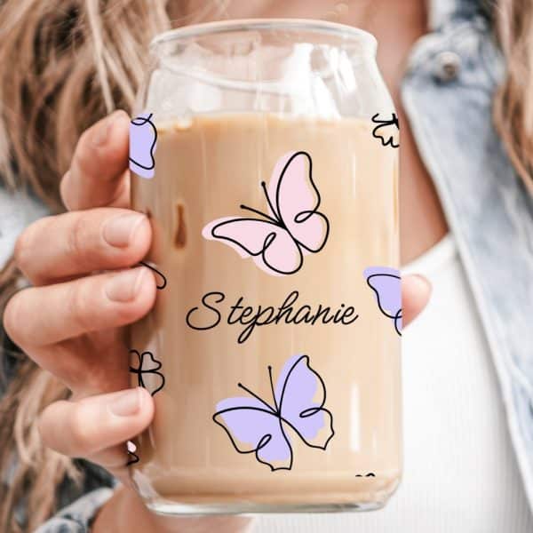 A Hand Holds A Glass Iced Coffee Cup Decorated With Butterflies And The Name Stephanie.