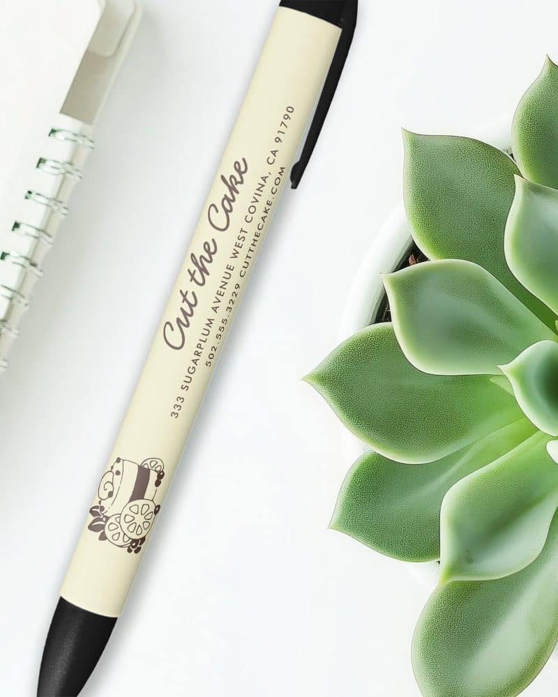 Cream-colored pen with black accents and Cut the Cake bakery logo.