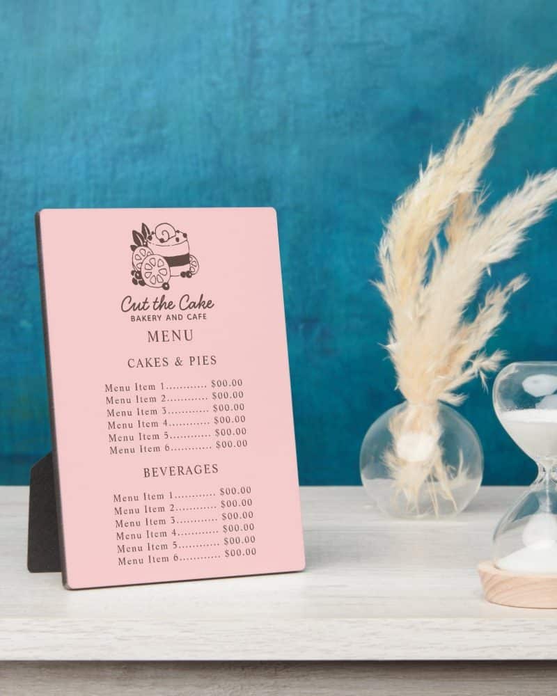 Pink menu for Cut the Cake bakery and cafe, showing prices for cakes, pies, and beverages.