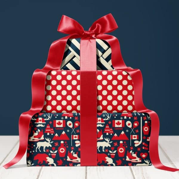 Stack Of Three Presents Wrapped In Festive Canadian-Themed Paper, Tied With A Large Red Ribbon.