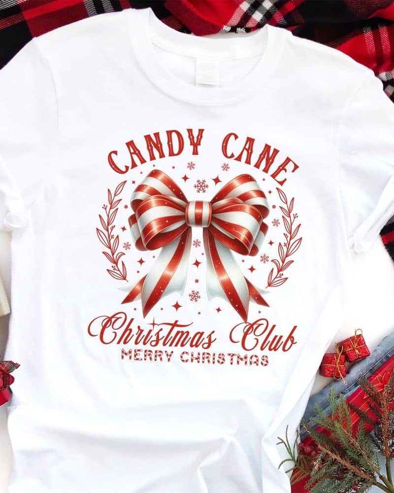 White t-shirt with a red and white candy cane bow design, text reading Candy Cane Christmas Club Merry Christmas.