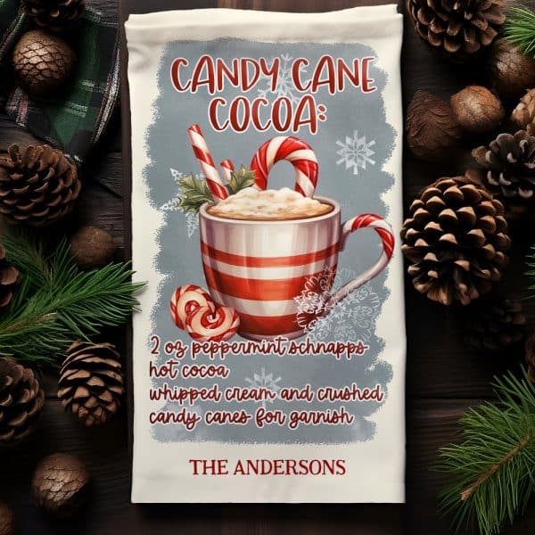 A Tea Towel With A Design Featuring A Mug Of Hot Cocoa Garnished With Candy Canes And Whipped Cream. The Text Includes A Recipe And The Name Andersons.