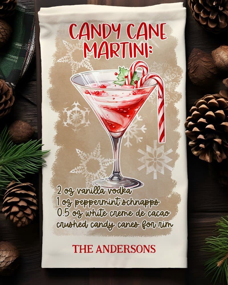 A kitchen towel with a recipe for a Candy Cane Martini, illustrated with a watercolor-style martini glass garnished with a candy cane.