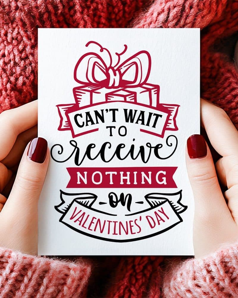 Two hands hold a Valentines Day card that says Cant wait to receive nothing on Valentines Day. A drawing of a present with a bow is above the text.