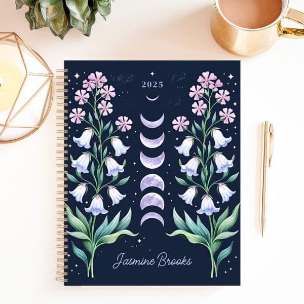 2025 Spiral-Bound Planner With A Dark Blue Cover Featuring Symmetrical Floral Designs And Phases Of The Moon, Personalized With The Name Jasmine Brooks.