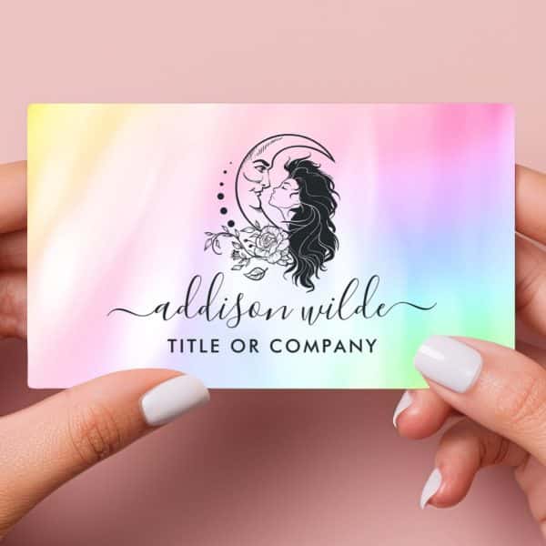 A Pastel Iridescent Business Card Featuring A Logo Of A Woman And A Crescent Moon Embracing, Adorned With Flowers. The Name Addison Wilde Is Displayed Below.