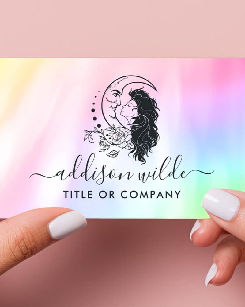 A pastel iridescent business card featuring a logo of a woman and a crescent moon embracing, adorned with flowers. The name Addison Wilde is displayed below.