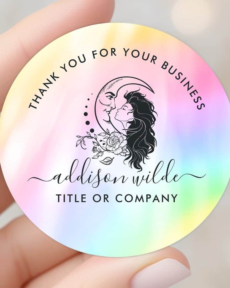 Pastel iridescent round sticker featuring a black line art design of a woman and man kissing within a crescent moon, with text that says Thank You For Your Business, Addison Wilde, Title or Company.